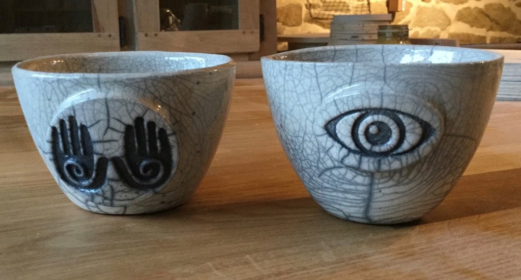 bol en raku avec motif mains et oeil