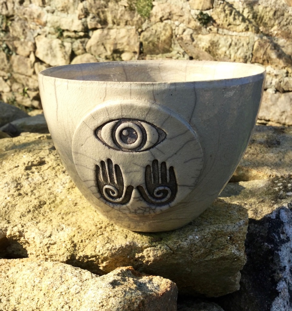 grand bol raku avec motif oeil et mains